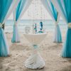 Blue and white wedding aisle in a beach surrounded by palms with the sea on the background Blue and white wedding aisle in a beach surrounded by palms with the sea on the background