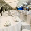 Banquet hall decorated in white with round served tables and sta Banquet hall decorated in white with round served tables and sta